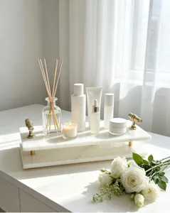 Detail of luxury white marble tray with gold handles for elegant makeup and perfume display.