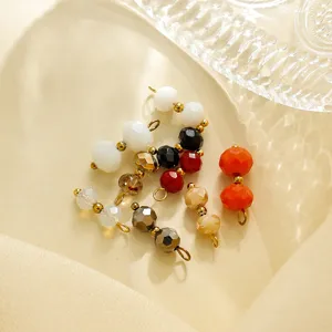 Detailaufnahme von bunten facettierten Kristallperlen mit goldenen Ringen für DIY Schmuck.
