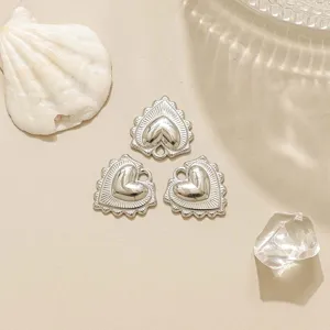 Primo piano dettagliato di ciondolo a cuore in argento con design vintage in rilievo per gioielli DIY.