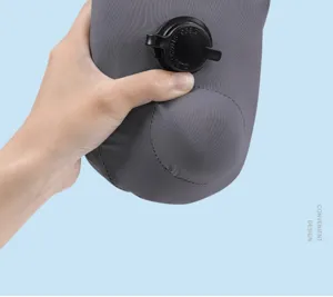 Close-up detail of the portable press-to-inflate travel neck pillow in dark grey.