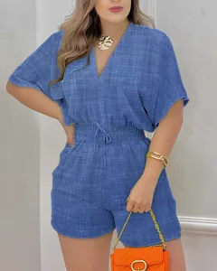 Detalle en primer plano del mameluco corto de verano azul para mujer con cuello V y cordón.
