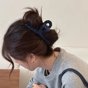 Detailansicht der dunkelblauen Samt-Kreuz-Haarklammer, elegantes Styling-Accessoire für Chignons.