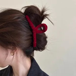 Nahaufnahme des eleganten roten Samthaar-Klammerclips, sicher am Haarknoten getragen.