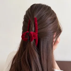 Nahaufnahme einer eleganten roten Samt Haarklammer mit Kreuz Design für Frisure.