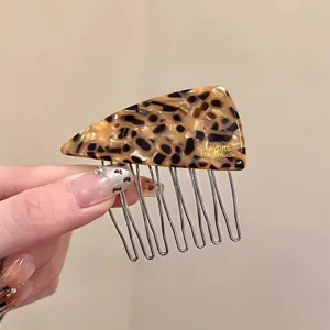 Detailed view of tortoise shell acetate triangle hair comb with metal teeth for side styling.