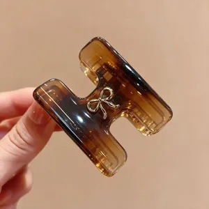 Molla per capelli in acetato stile coreano a forma di H, design tartarugato con fiocco in metallo.