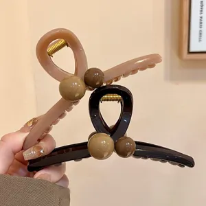 Nahaufnahme Detail braune Perlen Haarklammer mit eleganten kontrastierenden runden Perlen.