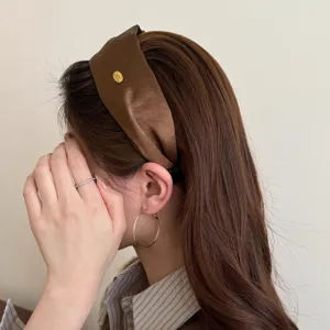 Nahaufnahme des braunen mercerisierten breiten Haarreifs, elegante Seitenansicht Lifestyle.