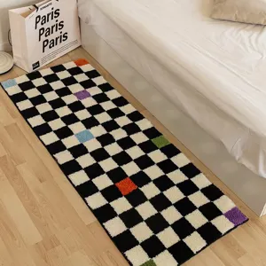 Detailed view of the black and white checkerboard bedside rug, soft plush texture for bedroom.