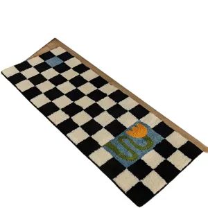 Black and white checkered bedside rug with blue and yellow flower pattern, soft cashmere-like runner.