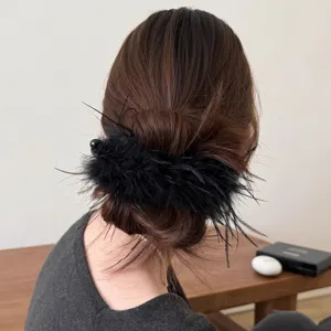 Detailed back-view shot of a fluffy black feather hair clip worn on tied-up brown hair.