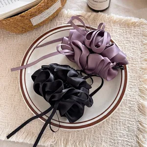 Vista detallada de pinzas para el cabello con lazo de satén estilo coreano en morado y negro.