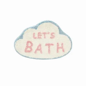 Detail shot of the cute cloud shaped tufted rug with blue border and pink letters text.