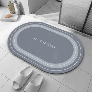 Tapis de bain ovale gris en terre de diatomée avec lignes blanches élégantes et texte absorbant.