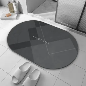 Détail de tapis de bain ovale en terre de diatomée gris, surface antidérapante.