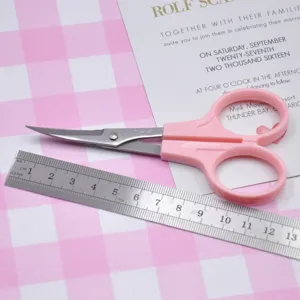Pink curved detail scissors closeup, precision craft tool for clay and paper DIY projects.