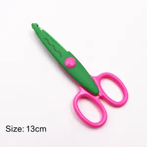 Close-up detail view of the green and pink plastic craft scissors with wavy blade pattern.