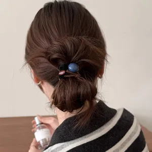 Vue détaillée d'un chouchou élégant pour cheveux avec perle bleue, accessoire de coiffure.