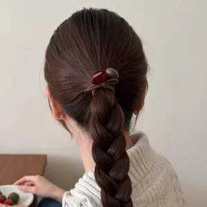 Gros plan détail d'élastique à cheveux mignon ours marron avec velours rouge sur cheveux.