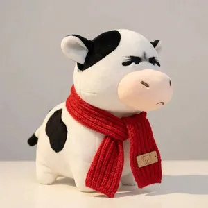 Niedliches Plüschkuh Kuscheltier Detailansicht mit rotem Strickschal weiche Puppe Geschenk.