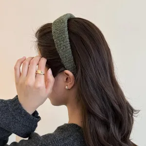 Detailansicht eines dicken gestrickten breiten Haarreifs in Dunkelgruen, Haar-Accessoire.