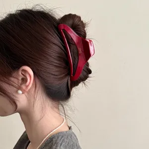 Nahaufnahme Detail einer roten Acetat ausgehöhlten großen Haarklammer für elegantes Styling.