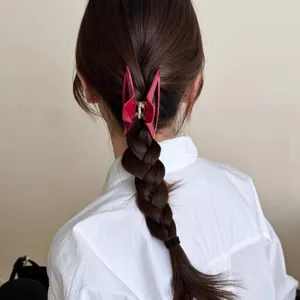 Nahaufnahme der rosafarbenen hohlen Haarklammer mit elegantem Design auf geflochtenem Haar.