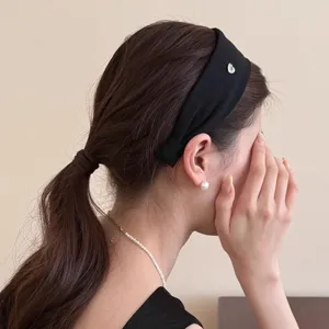 Minimalistisches schwarzes breites Stirnband mit zartem Metalldetail, elegantes Haaraccessoire.