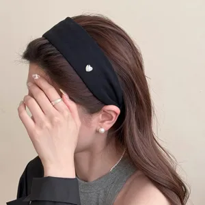 Minimalistischer schwarzer breiter Haarreif mit Herzanhänger für elegante Alltagsfrisuren.