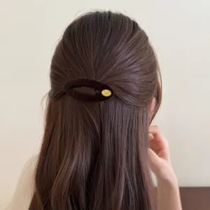 Braune Samt Haarklammer mit Metallschild für elegante Frisuren, schickes Accessoire.