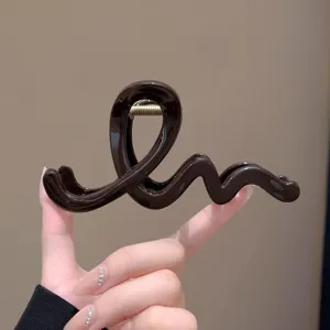 Nahaufnahme einer schicken dunkelbraunen welligen Haarklammer, eleganter Haarschmuck.