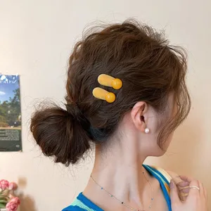 Nahaufnahme Detail der modischen gelben runden Haarspangen für Damen, idealer Haarschmuck.