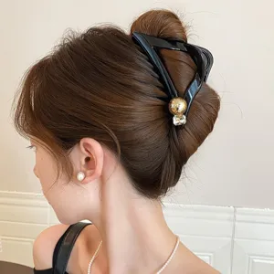 Modische schwarze dreieckige Haarklammer mit Kristall und Goldkugel für elegante Damen Frisuren.