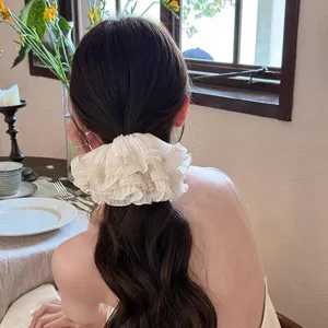 Detail shot of French lace hair scrunchie, elegant ruffled hair tie for women low ponytail.