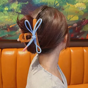 Primer plano de una bonita pinza para el cabello con lazo azul llevada en el moño alto.