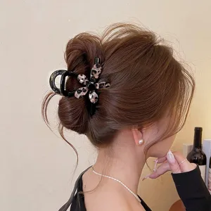 Vista dettagliata della pinza per capelli con stampa leopardata a fiore su uno chignon.