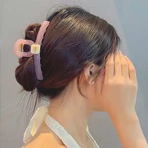 Detailansicht der eleganten rosa Haarklammer mit goldenem Welpen-Akzent fuer das taegliche Styling.