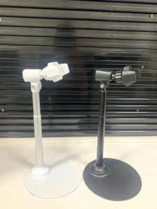 Desktop phone stand detail view, showing black and white metal bracket with stable round base.