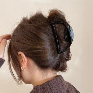 Nahaufnahme einer eleganten schwarzen Halbkreis-Haarklammer, stilvoll getragen im Haar.