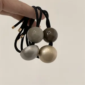 Detail view of minimalist retro spherical hair tie with high elasticity and glossy balls.