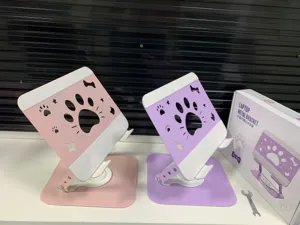 Detail shot of cute cat paw metal laptop stand, 360-degree rotating desktop mount in pink.