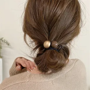 Detail shot of minimalist retro double ball hair tie, perfect for low ponytail styling.