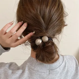 Minimalist retro double sphere hair tie detail, elegant low ponytail accessory for women.