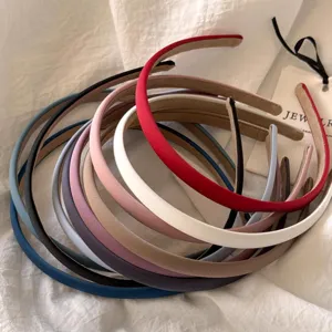 Nahaufnahme von bunten schmalen Lederhaarreifen, minimalistisches Haarschmuck-Accessoire.