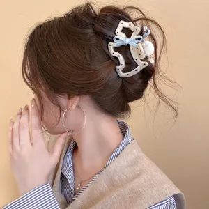 Cute bow polka dot hair claw clip for women, stylish acetate hair accessory for half updo.