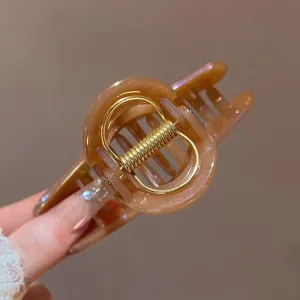Elegante molletta per capelli in acrilico marrone vista dettaglio per acconciature chic