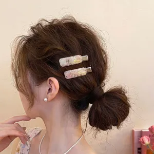 Detailansicht modischer Acetat-Haarspangen an einem asiatischen Model, elegant und schick.