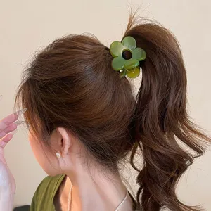 Primo piano dettaglio di un fermaglio per capelli a forma di fiore verde alla moda.
