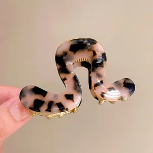 Elegante haarklem van acetaat met schildpadpatroon en gouden tanden voor mooie kapsels.