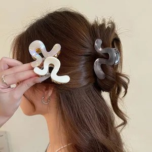 Elegante acetaat haarclip met uniek onregelmatig golvend ontwerp voor modieuze dameskapsels.